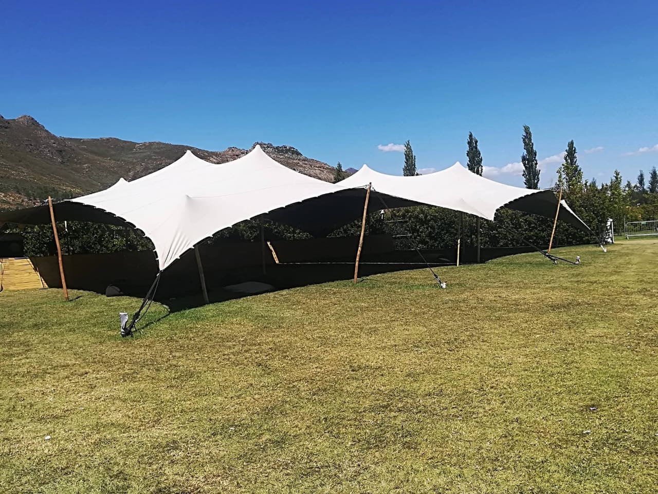Connected white stretch tents at an outdoor venue