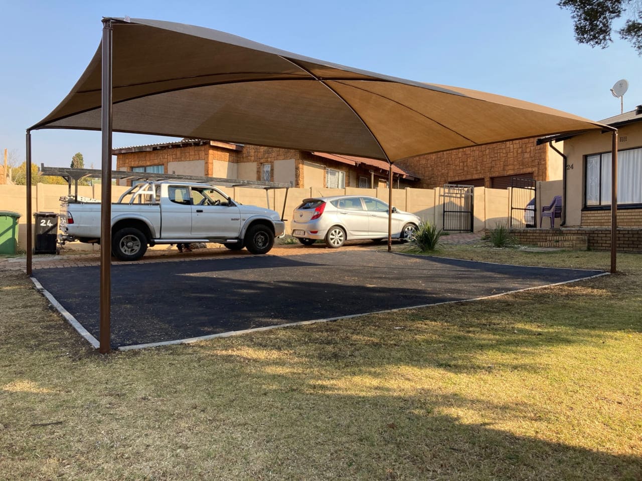 Fabric shadeport covering parked vehicles